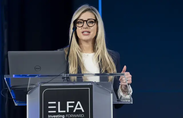 Presenter speaking at an ELFA podium during a conference.